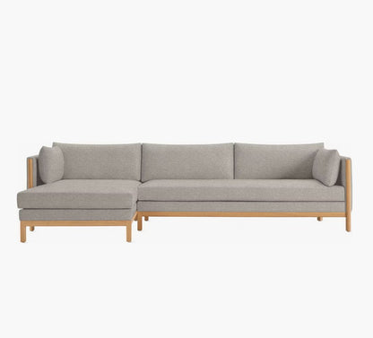 The Emmy Sectional is a stylish, modern sofa in light gray with wooden legs and a left-side chaise. It showcases clean lines and a minimalistic design, perfect for contemporary interiors.