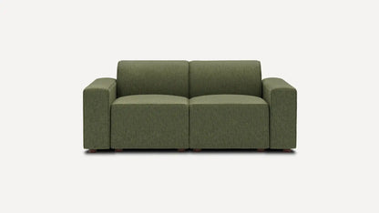 The Mambo Loveseat is a modern, green two-seater sofa featuring a minimalist design with square arms. It is set against a plain white background, showcasing its subtly textured fabric and small dark wooden legs.