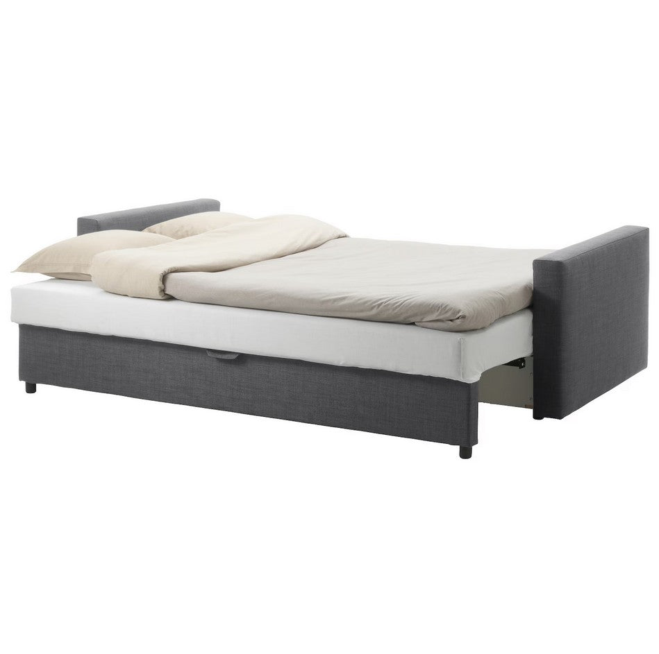 A sleek FRIHETEN Sleeper Sofa in gray is transformed into a bed, adorned with light beige bedding and two pillows. The design includes rectangular armrests and is elevated on black legs.