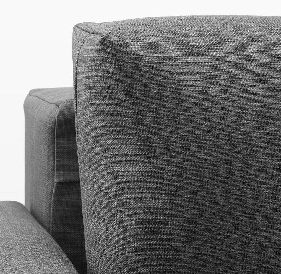 A close-up of the FRIHETEN Sleeper Sofa showcases its modern dark gray fabric, emphasizing the textured upholstery and the clean, angular lines of its armrest and back cushion. The fabric is tightly woven, contributing to its minimalist design.