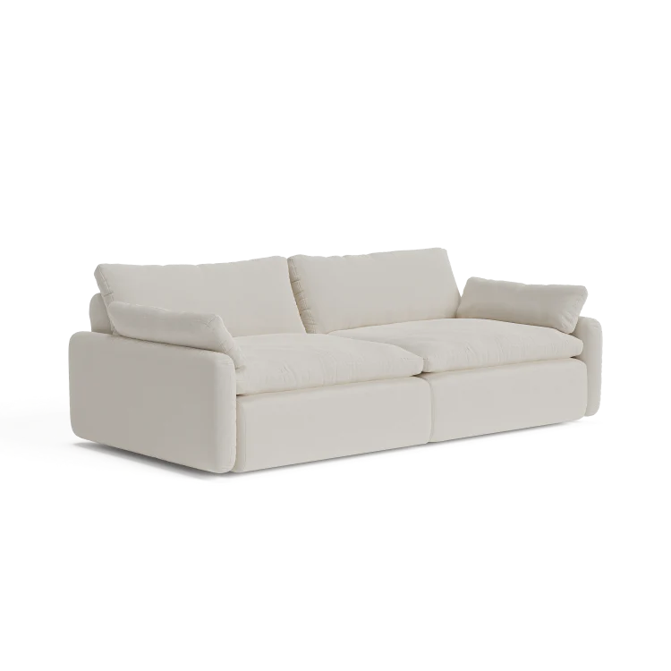 Introducing The Sink Down Sectional, a trendy white sofa with a sleek modern design. It showcases thick cushions and armrests, making it the ideal choice to bring a contemporary feel to any living room.