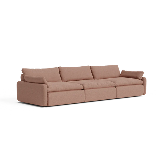 The Sink Down Sectional offers a modern design in beige, featuring three spacious seats with large, plush cushions and armrests on each end. Its simple, clean style makes it ideal for a contemporary living room setting.