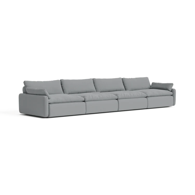 The Sink Down Sectional is a long, modern light gray sectional sofa that includes five large cushions. It boasts clean lines and a minimalist design, making it ideal for a contemporary living room against a plain white background.