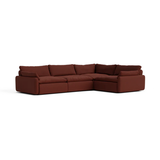 The Sink Down Sectional is a large, L-shaped, brown sofa featuring plush cushions and a low backrest, all set against a white background. Its modern design includes deep seating for enhanced comfort.