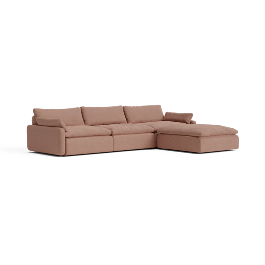 Introducing The Sink Down Sectional: a contemporary L-shaped sofa in a cozy warm brown tone. This sectional boasts a smooth texture, complete with three main seat cushions and an attached chaise on the right side. The plush back cushions provide exceptional comfort for a relaxing seating experience.