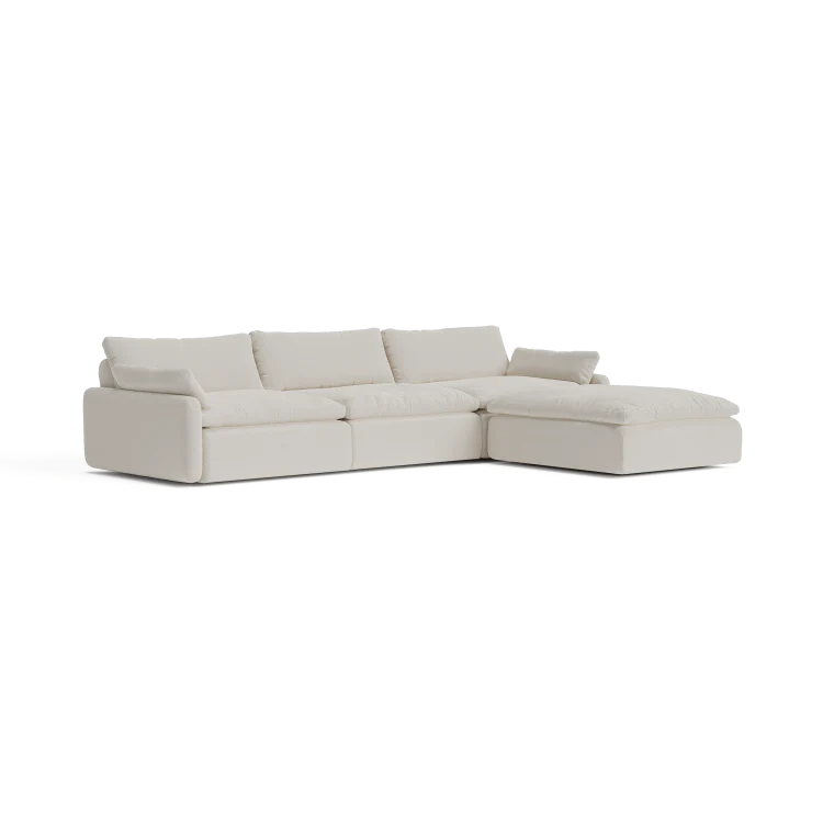 The Sink Down Sectional is a contemporary L-shaped white sofa featuring plush cushions and a right-side chaise lounge, set against a plain background.