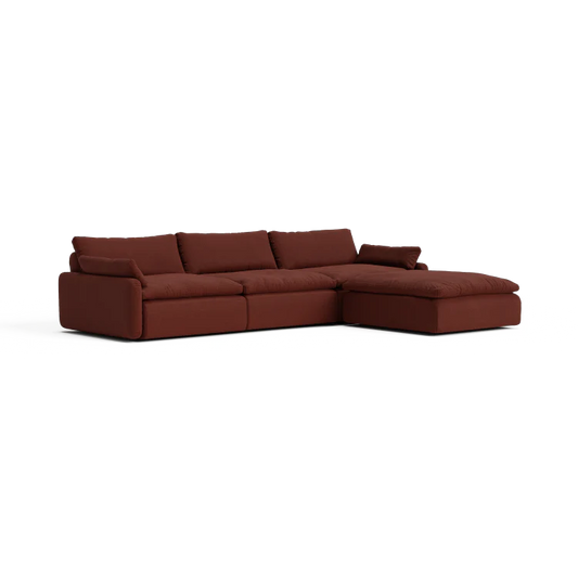 Introducing The Sink Down Sectional – a dark brown sofa featuring plush cushions and a modern design. With its right-side chaise extension, it’s perfect for lounging and relaxation.