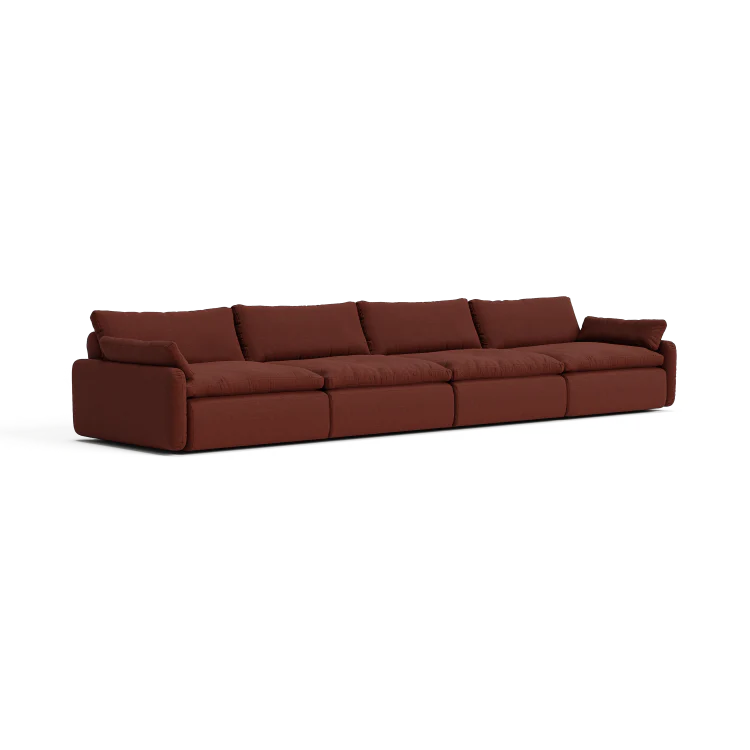 The Sink Down Sectional is a contemporary, extended sofa with a luxurious deep brown fabric finish. It consists of five interconnected seats, complete with plush backrests and armrests at both ends, showcased against a clean white backdrop.