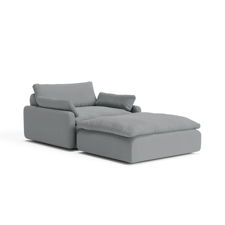 Introducing The Sink Down Sectional, a contemporary gray sectional perfectly paired with an ottoman, showcasing plush cushioning and a sleek, minimalist design against a pristine white backdrop.