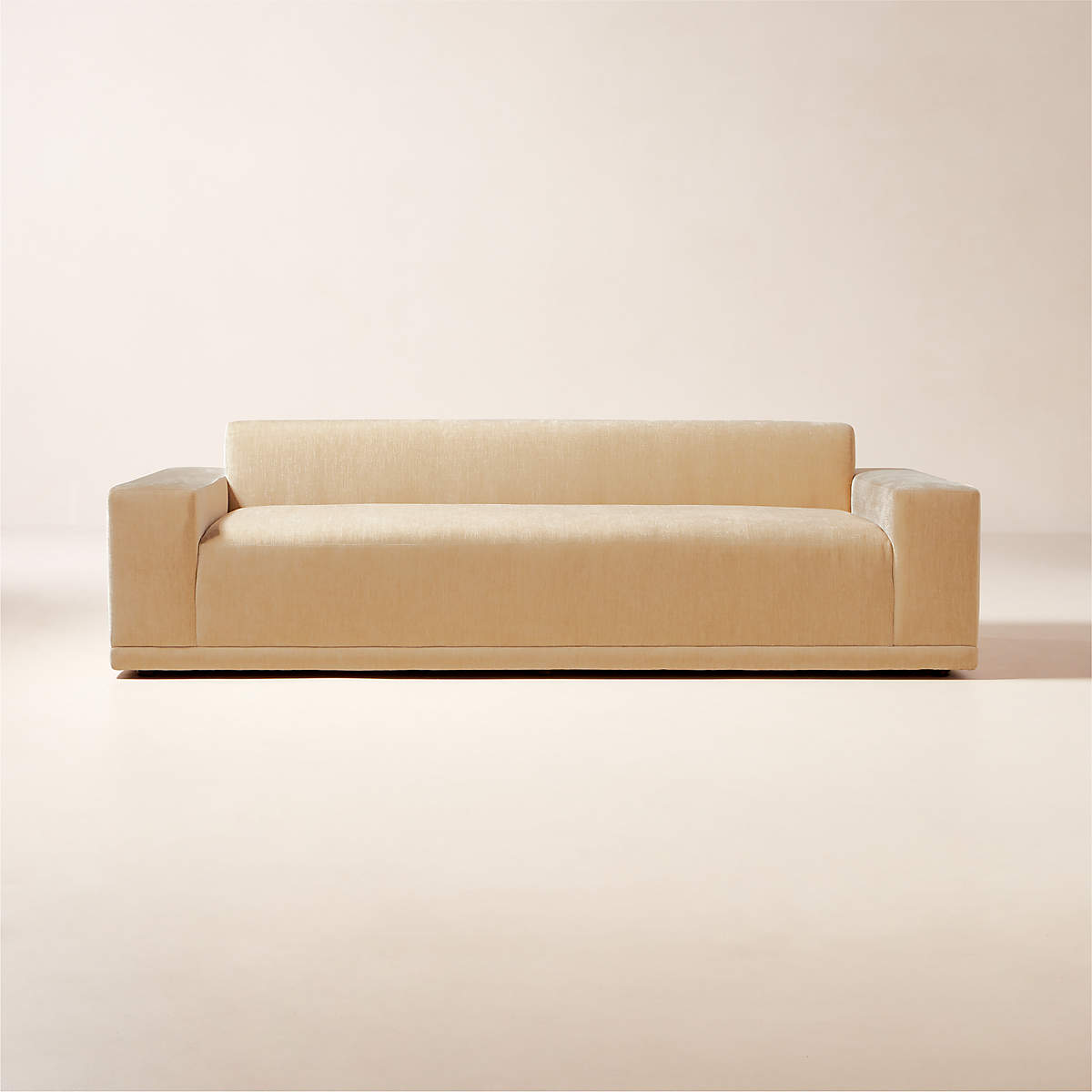 The Faible 100" White Performance Fabric Sofa features a beige, modern, minimalist design with clean lines and low-profile armrests set against a neutral background.