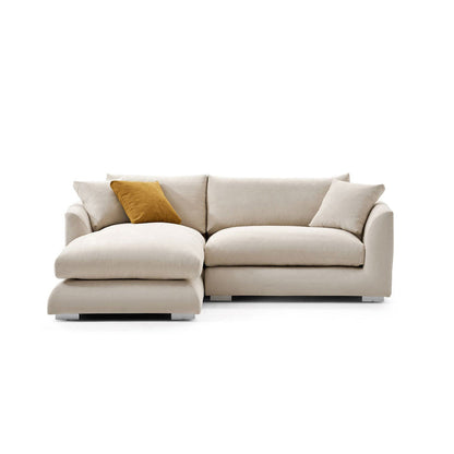 The Feathers 88" Left Facing Sectional is a beige sectional sofa with three cushions and a chaise lounge on the left side. It includes a single mustard yellow throw pillow for contrast and rests on short, subtle legs, all set against a plain white background.