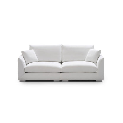 Introducing the Feathers 3-Seater Sofa, a sleek and modern white sofa accompanied by two matching cushions. Set on a plain white background, this sofa features a minimalist design with smooth, rounded armrests and plush seating, epitomizing clean elegance.