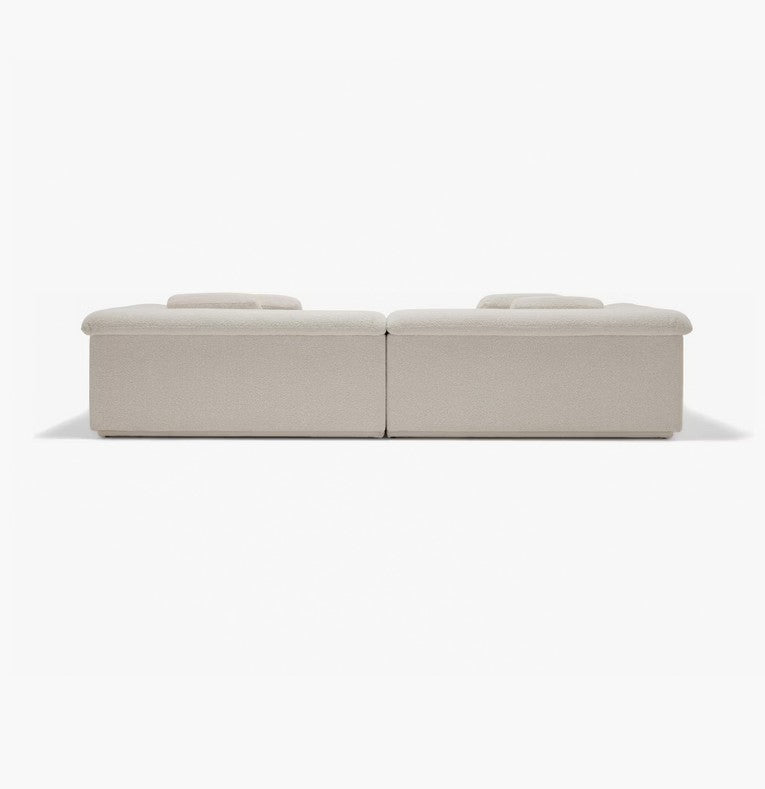 The image displays the Float Sofa, a minimalistic beige modular sofa set against a plain white background. It features two low-profile sections with flat cushions that highlight its modern and understated design.