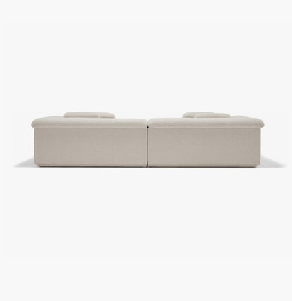 The image displays the Float Sofa, a minimalistic beige modular sofa set against a plain white background. It features two low-profile sections with flat cushions that highlight its modern and understated design.