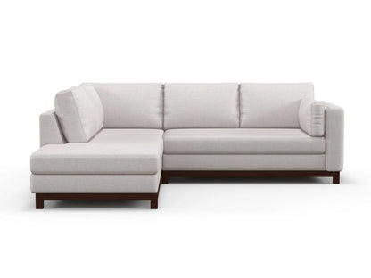 Introducing the Florida Bumper 96" Sectional, a contemporary L-shaped sofa featuring light gray upholstery and plush cushions. This sectional includes a left-side chaise and rests on dark wooden legs, all set against a plain white backdrop.