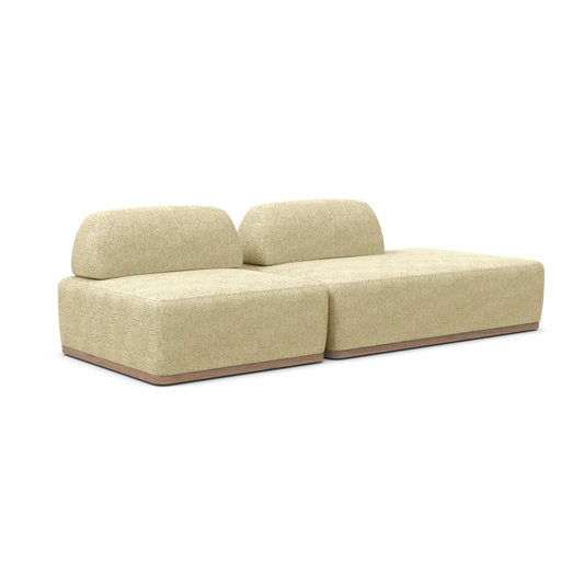 Introducing the Magna Preconfigured Sectional, a minimalist modern beige sectional sofa featuring two backrests and a wooden base. This stylish seating option consists of two connected pieces, providing spacious and contemporary comfort.