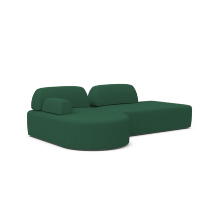 The Magna Preconfigured Sectional is a green sofa with rounded edges, featuring a chaise lounge on the right side. Its design is modern and minimalist, showcasing smooth, clean lines and concealed legs.