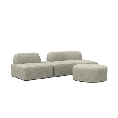 The Magna Preconfigured Sectional is a modern, light gray modular sofa with clean lines, complemented by a matching round ottoman. Both pieces boast a textured fabric, offering a cohesive and sleek appearance.