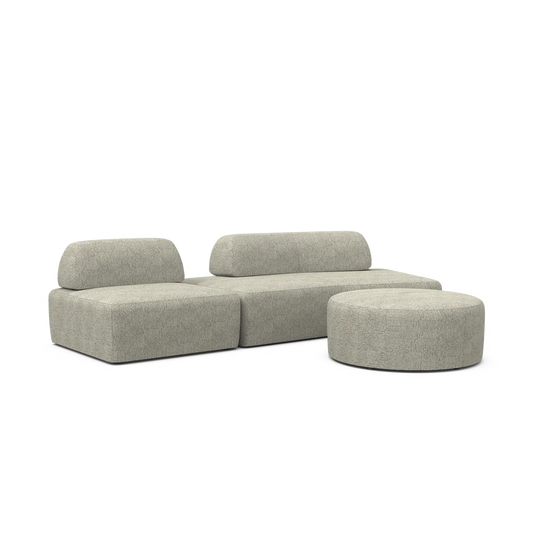 The Magna Preconfigured Sectional is a modern, light gray modular sofa with clean lines, complemented by a matching round ottoman. Both pieces boast a textured fabric, offering a cohesive and sleek appearance.