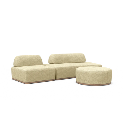 The Magna Preconfigured Sectional is a modular beige sofa set featuring a minimalist design with three cushioned sections and an additional separate round ottoman. It is upholstered in textured fabric and boasts a low, modern profile.