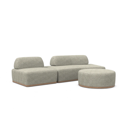 Introducing the Magna Preconfigured Sectional: a modern, minimalist sofa set featuring cream-colored upholstery. This elegant ensemble includes a sectional sofa with two backrests and a coordinating round ottoman, all designed with wooden bases and soft, rounded shapes. Perfectly showcased against a plain white background for a chic aesthetic.