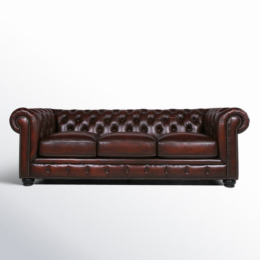 The Birch Lane Freddie 95'' Leather Sofa features a classic dark brown Chesterfield design with deep button tufting, rolled arms, and three seat cushions. The sofa is set against a plain white background, highlighting its elegant and traditional style.