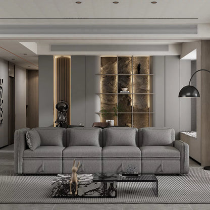 A contemporary living room showcases a ModernLuxe 122.8" Minimalist Convertible Modular Sofa in gray, accompanied by a sleek black floor lamp and a stylish glass coffee table. The scenery includes a wall accented with vertical lighting and shelves adorned with artistic decor pieces, creating a space that embodies minimalist elegance.