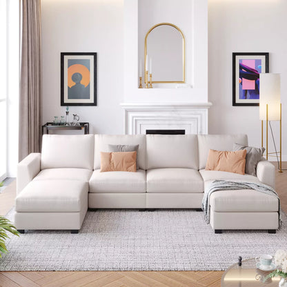 A modern living room featuring the ModernLuxe 3 PCS U-shaped Upholstered Sectional Sofa with Removable Ottomans, elegantly adorned with peach pillows and a gray throw. A white fireplace, enhanced by a mirror above it, is flanked by abstract art pieces. The space is completed with a floor lamp and side table.