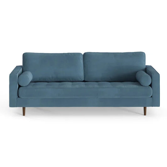 The Geo 84'' Upholstered Sofa features a sleek, minimalist design with a modern blue hue, two rectangular back cushions, and two cylindrical armrest pillows. Its wooden legs add to its elegance, while the white background enhances its vibrant color and chic style.