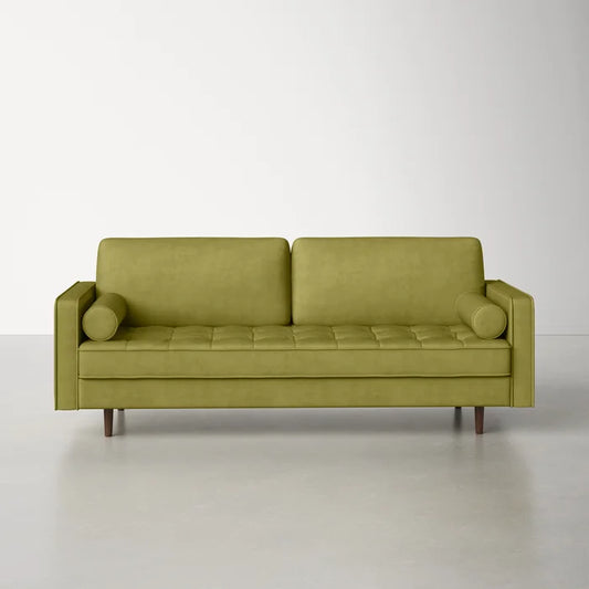 The Geo 84'' Upholstered Sofa is a minimalist olive-green piece with a button-tufted seat and two cylindrical pillows, set against a plain white background. It features wooden legs and boasts a modern design.