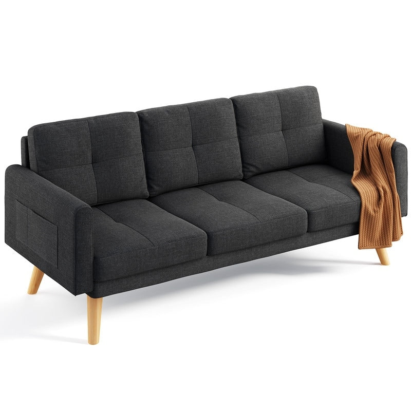 A Sofa Couch Small Loveseat in dark gray, featuring light wooden legs and a minimalist design, comes with three comfy pillows. The tufted back cushions add an elegant touch, while a textured brown throw is gracefully draped over one armrest.