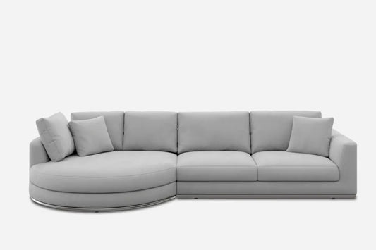 A modern, light gray sectional sofa with a round left chaise and four square back cushions. The sofa includes two smaller square pillows, set against a white background.