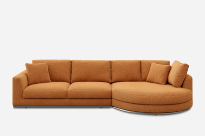 Orange, L-shaped sofa with a textured, boucle fabric. It features three rectangular seat cushions, a round chaise at one end, and five matching square pillows. The sofa rests on a minimalistic base against a plain white background.