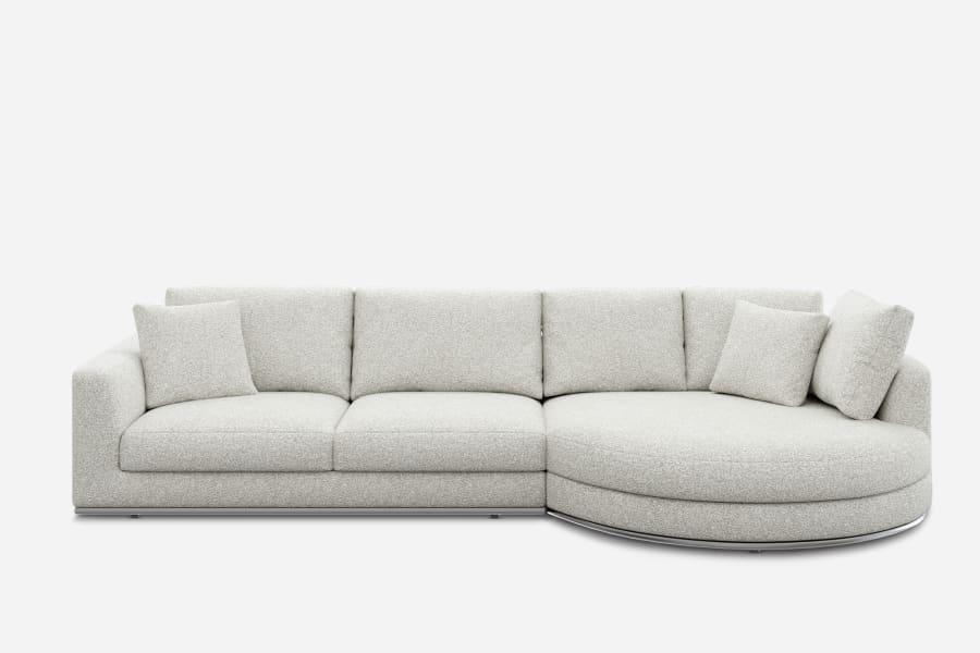 A light gray sectional sofa with an L-shaped design, featuring three seat cushions, three back cushions, and a rounded chaise lounge on the right. The sofa is set against a plain white background.