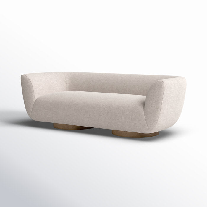 The Holloman 87'' Upholstered Sofa, featuring a modern design with off-white upholstery, curved edges, and low wooden legs, is showcased against a light gradient background.