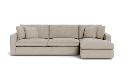 The James 3 Seat Left Chaise 92" Sectional is a beige sectional sofa featuring three seat cushions and an attached chaise on the left. It comes with three matching throw pillows, providing a clean and modern design.