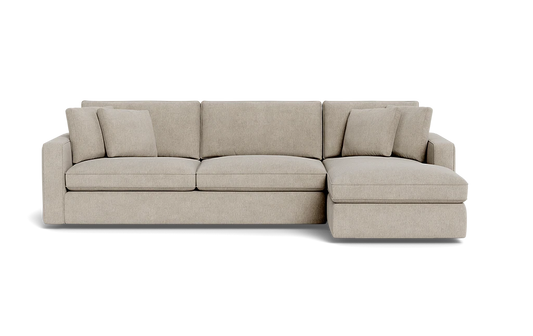 The James 3 Seat Left Chaise 92" Sectional is a beige sectional sofa featuring three seat cushions and an attached chaise on the left. It comes with three matching throw pillows, providing a clean and modern design.