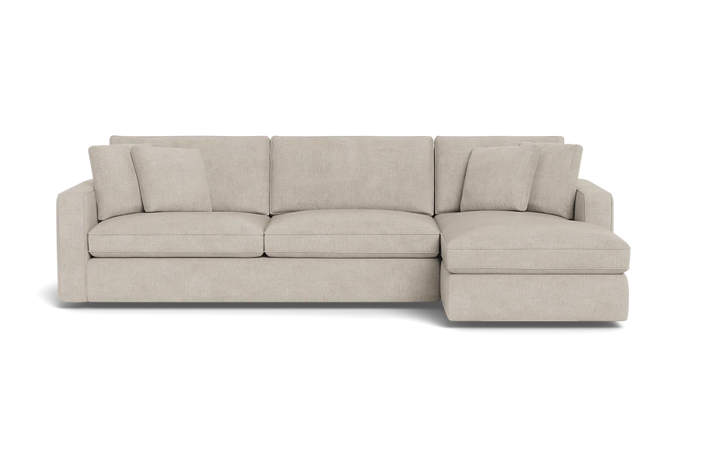 The James 3 Seat Left Chaise 92" Sectional is a beige L-shaped sofa with three cushions. It boasts clean lines and plush seating, featuring a left-side chaise lounge and a modern design. Its neutral color offers versatility for various decor styles.