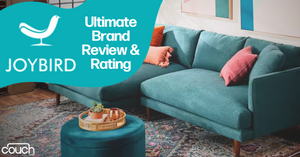 A teal-colored sectional sofa with pink and orange cushions is placed in a modern living room with a patterned rug. A circular tray with decorative items is on the coffee table. The text on the image reads "Joybird: Ultimate Brand Review & Rating" with a bird logo.