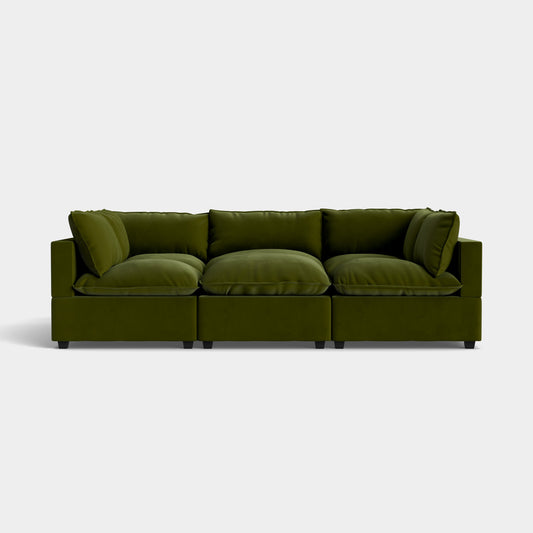 Introducing the Kova Pit, a contemporary green velvet sofa composed of three sections and adorned with plush cushions against a simple white background. The sofa showcases a minimalist design and offers deep, comfortable seating.