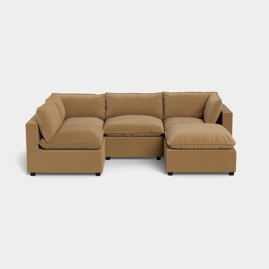 The Kova L Shape with Ottoman is a modular sectional sofa in a light brown color, comprising three connected pieces. It features plush cushions and showcases a modern design, all set against a plain white background.