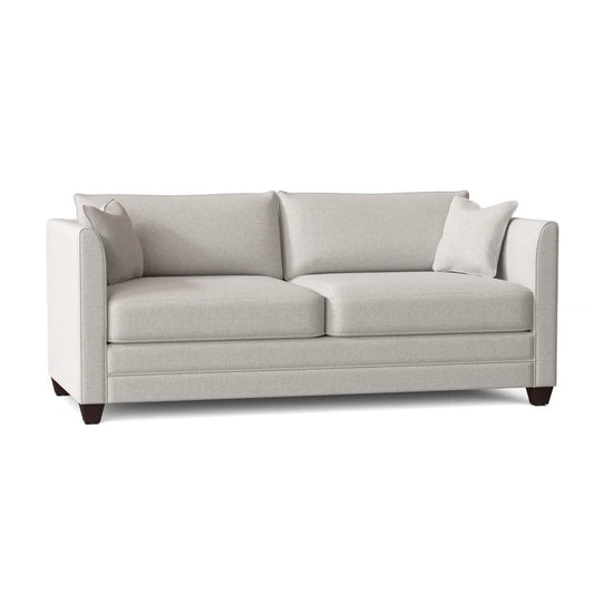 The Kodie 76.5" Upholstered Sleeper Sofa is a contemporary piece in a light gray hue, featuring two seat cushions and two back cushions. It is supported by dark wooden legs and includes two matching throw pillows, embodying a simple and elegant design perfect for any living room.