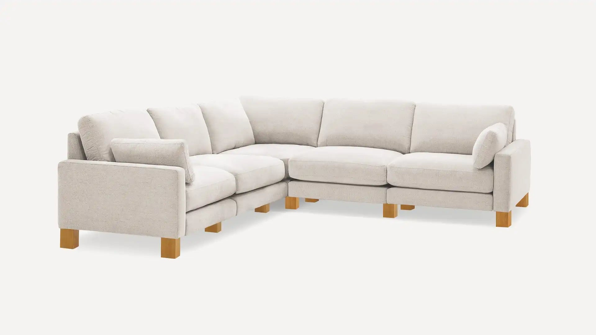 The Union Fabric Modular 5-Seat Sofa Sectional, a light gray L-shaped sofa with wooden legs, is displayed against a plain background. It includes numerous plush cushions that provide a modern and comfortable seating experience.