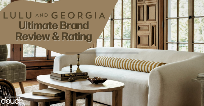 A stylish living room features a white sofa with a striped cushion, a wooden coffee table with books and a brass candlestick, and large windows. The image includes the text "Lulu and Georgia: Ultimate Brand Review & Rating" and a logo in the bottom left corner.