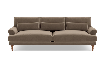 Maxwell Custom Sofa in brown velvet, featuring three seat cushions and three matching throw pillows. It boasts rounded armrests and wooden legs for a classic and cozy design.