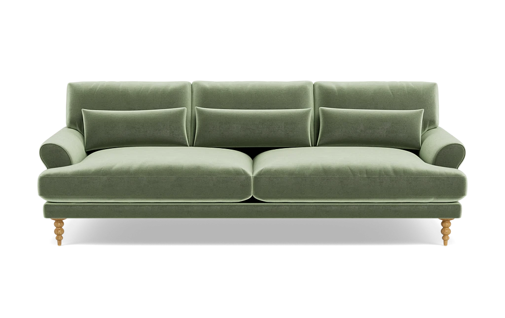 The Maxwell Custom Sofa is a chic piece, upholstered in luxurious green velvet, with three back cushions and two seat cushions. It is designed with rounded armrests and wooden legs, offering a modern and elegant appearance.