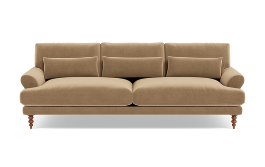 The Maxwell Custom Sofa is a beige, three-seater with plush cushions and rolled arms, supported by four wooden legs. It features three back cushions and a soft velvet-like texture, providing a cozy and elegant appearance against a plain background.