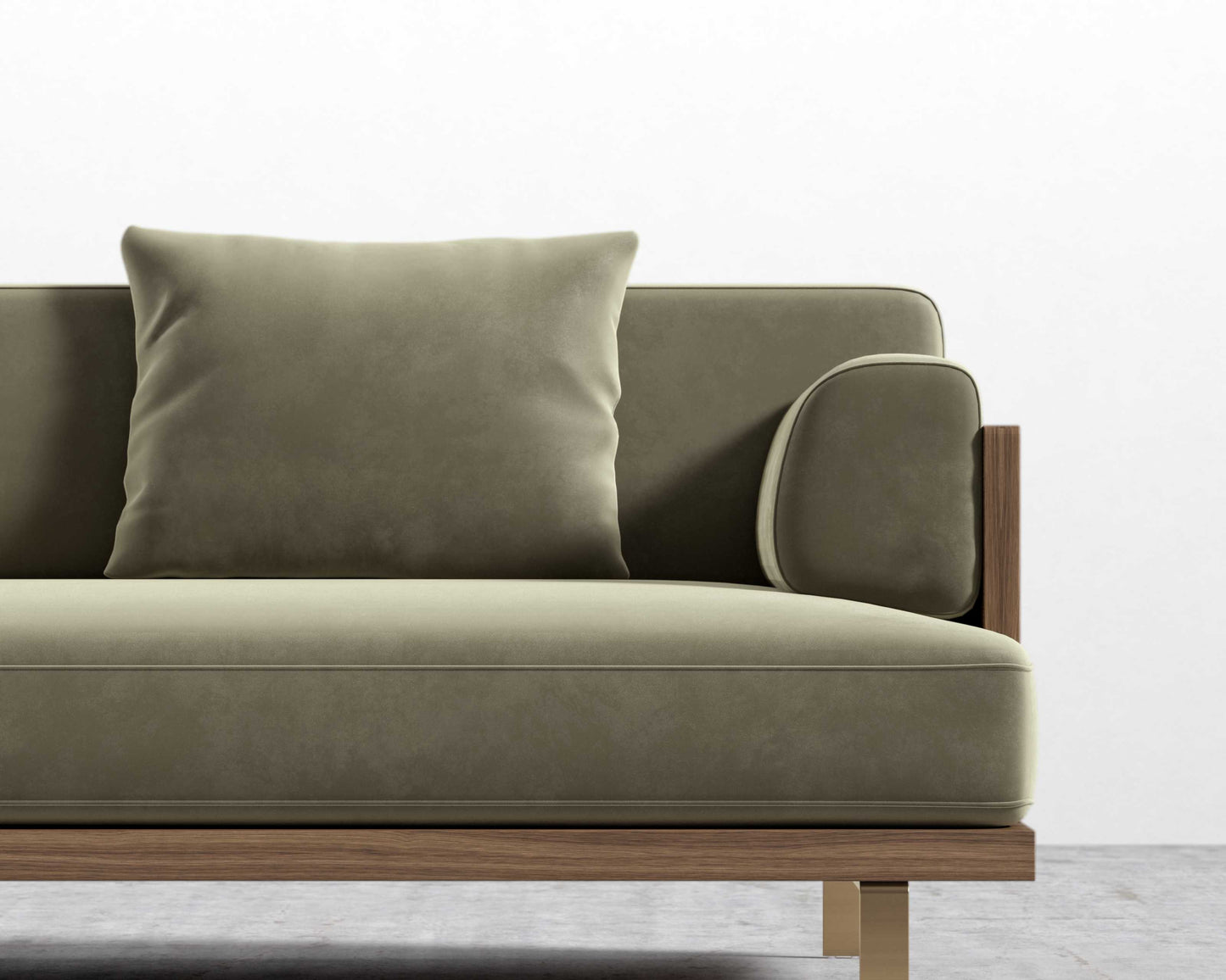 The Maria Sofa, featuring a contemporary green design with a wooden frame and matching cushion, is positioned against a simple white wall. The concrete floor enhances the minimalist aesthetic.