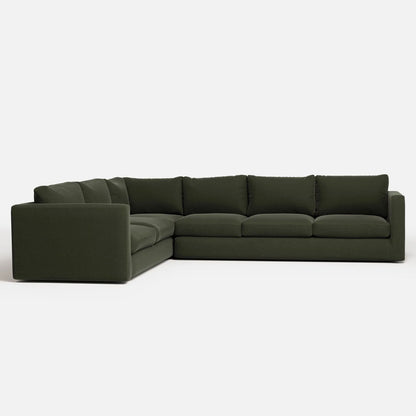 The Milo Sectional, a large L-shaped sofa in dark green, showcases thick cushions and a minimalist design, set against a plain white background.