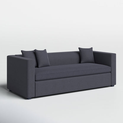 The Mono 81" Sleeper Sofa is a modern-style piece in dark gray, equipped with two square armrests and curved back edges. It includes two coordinating throw pillows and is positioned on a light gray floor against a plain white background.